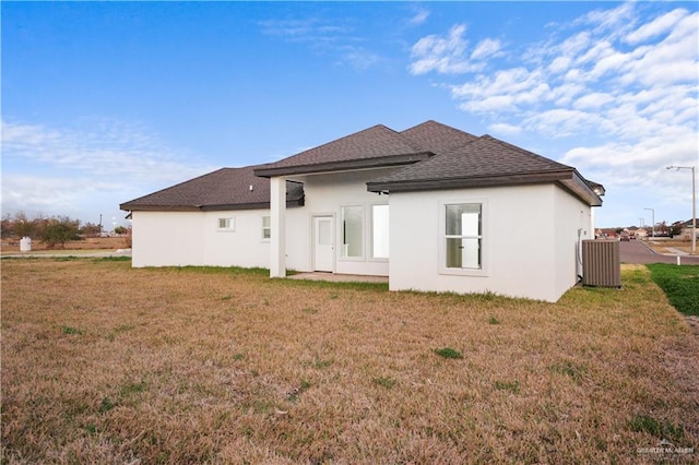 rear view of property with cooling unit and a yard