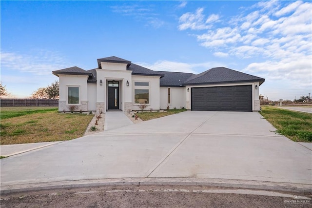 prairie-style home featuring a garage and a front lawn