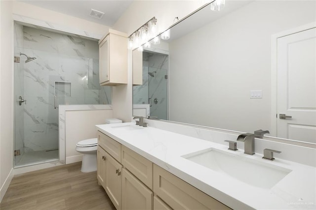 bathroom featuring vanity, hardwood / wood-style floors, toilet, and walk in shower