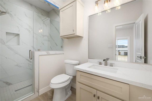 bathroom with a shower with door, vanity, hardwood / wood-style floors, and toilet