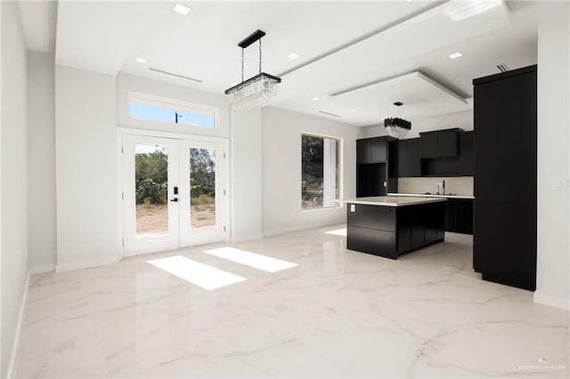 kitchen featuring pendant lighting, a center island, an inviting chandelier, and french doors