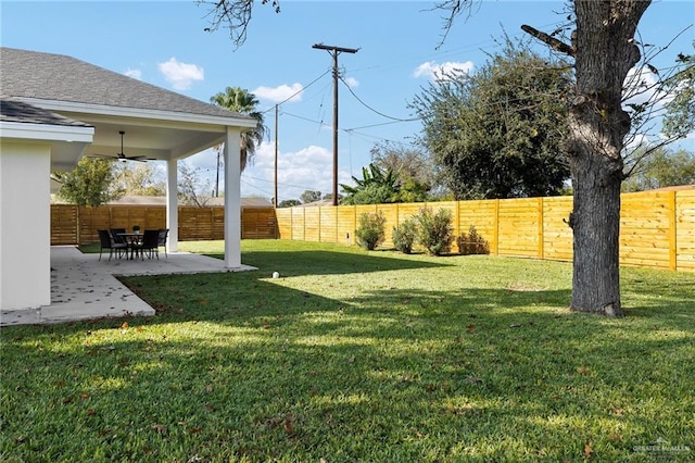 view of yard with ceiling fan and a patio