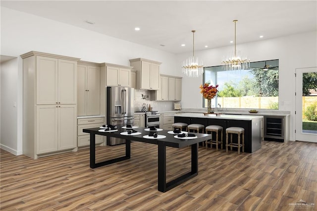 kitchen with a kitchen bar, a kitchen island, dark hardwood / wood-style floors, decorative light fixtures, and stainless steel appliances