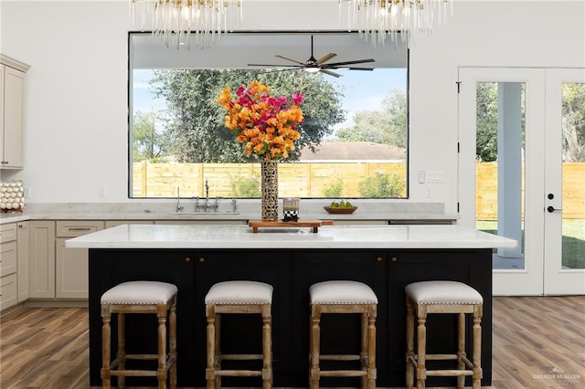 kitchen with sink, french doors, a kitchen island, and a breakfast bar area