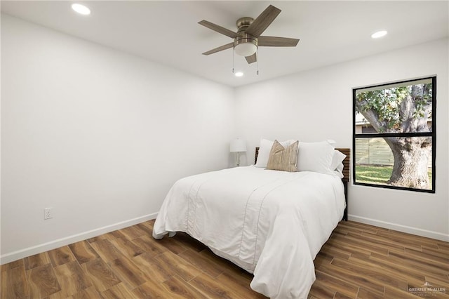 bedroom with ceiling fan and dark hardwood / wood-style flooring