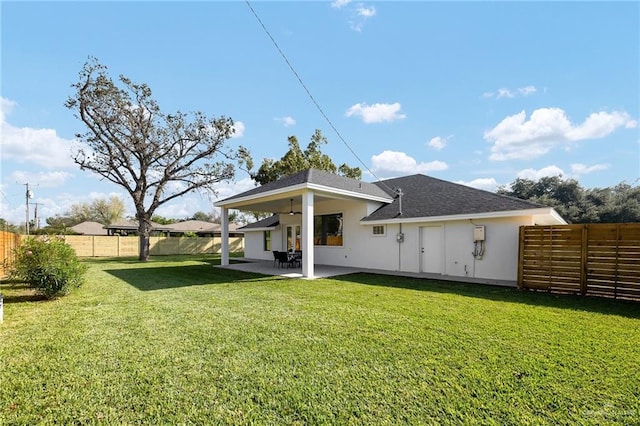 rear view of house with a yard, a patio, and ceiling fan