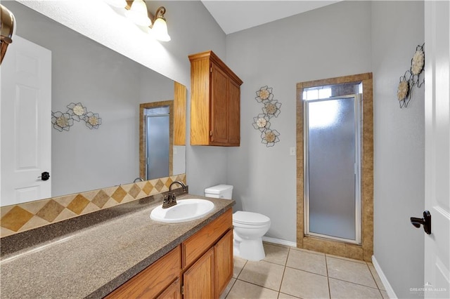 bathroom featuring a stall shower, baseboards, toilet, tile patterned floors, and vanity