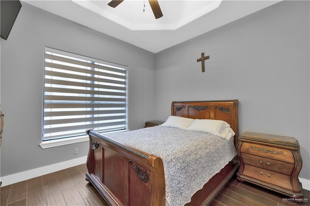 bedroom featuring a ceiling fan, dark wood finished floors, and baseboards