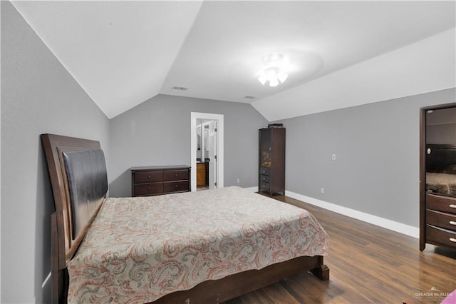 bedroom featuring dark wood-style floors, vaulted ceiling, and baseboards