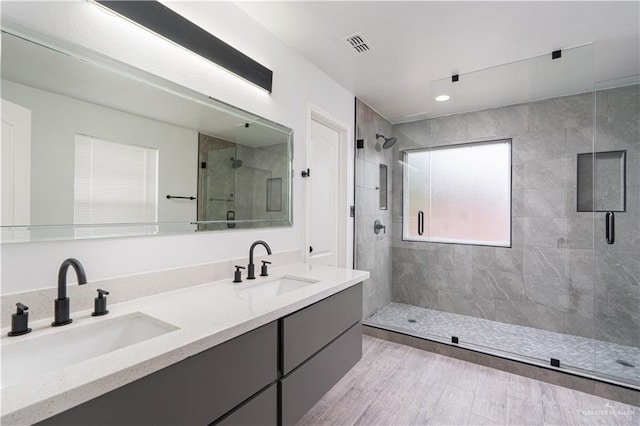 bathroom featuring vanity and a shower with shower door