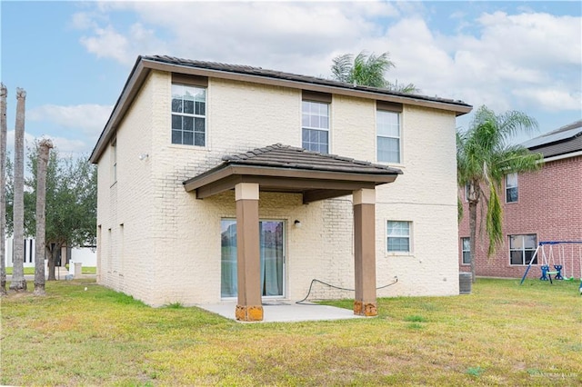 rear view of property featuring cooling unit, a lawn, and a patio area