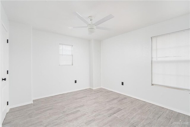 spare room with light wood-type flooring and ceiling fan