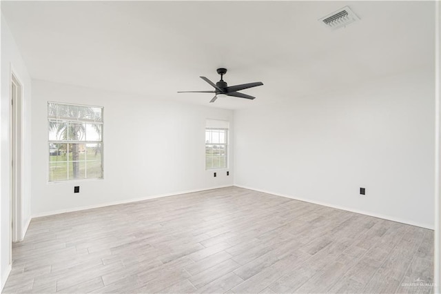 empty room with ceiling fan and light hardwood / wood-style flooring