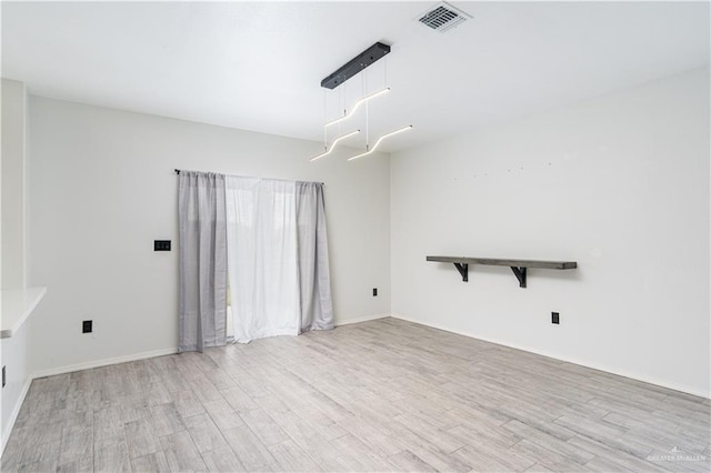 spare room featuring light hardwood / wood-style flooring