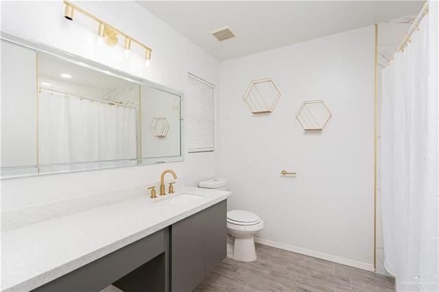 bathroom featuring vanity, hardwood / wood-style floors, and toilet