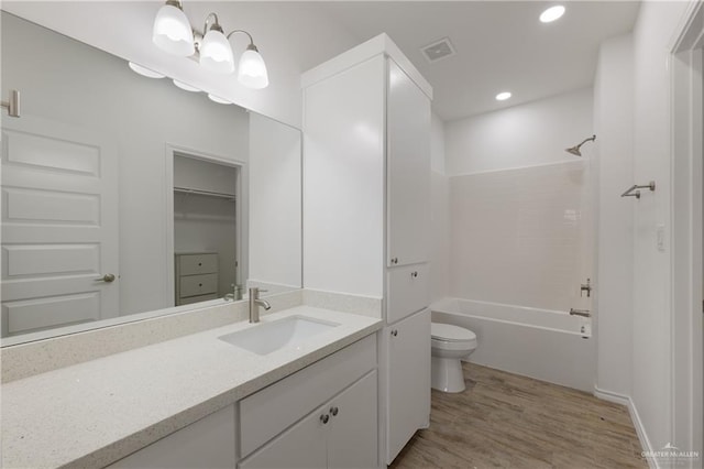 full bathroom featuring hardwood / wood-style flooring, vanity, toilet, and bathing tub / shower combination