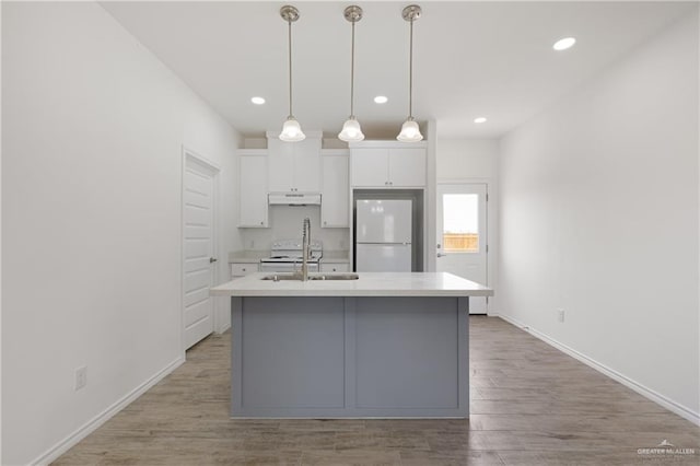 kitchen with white cabinetry, a center island with sink, white appliances, and sink