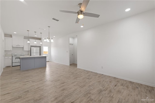 unfurnished living room with ceiling fan with notable chandelier and light hardwood / wood-style floors