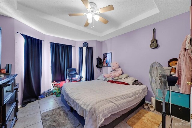 1604 E Kennedy Ave, Alton, TX 78573 - bedroom featuring a tray ceiling, ceiling fan, and tile patterned floors