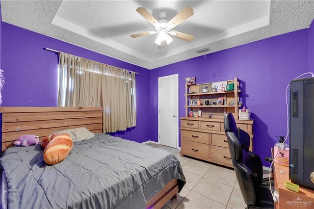 1604 E Kennedy Ave, Alton, TX 78573 - bedroom with a tray ceiling, a textured ceiling, a desk, light tile patterned floors, and a ceiling fan