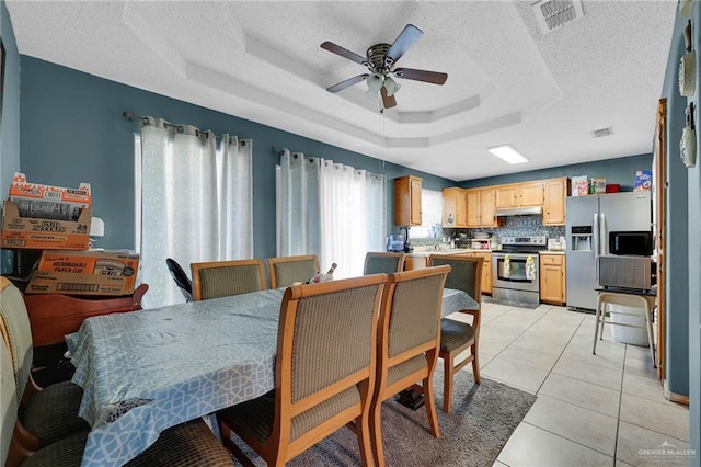 1604 E Kennedy Ave, Alton, TX 78573 - dining space featuring a tray ceiling, ceiling fan, a textured ceiling, and light tile patterned floors