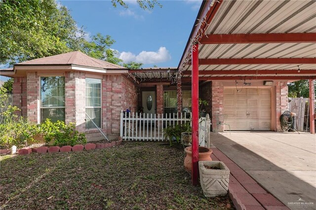 1604 E Kennedy Ave, Alton, TX 78573 - view of front of house featuring concrete driveway, brick siding, and a garage