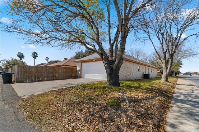 view of home's exterior with central AC and a garage