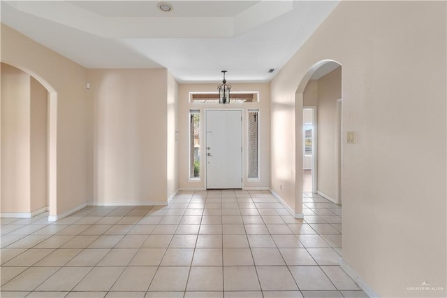 tiled foyer featuring a tray ceiling