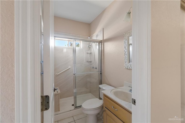 bathroom featuring vanity, tile patterned flooring, a shower with door, and toilet