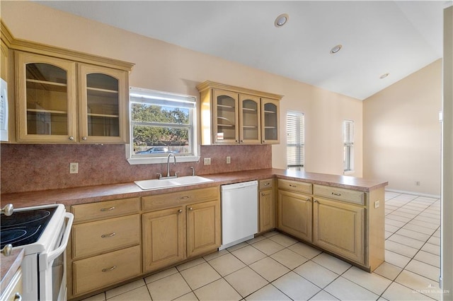 kitchen with lofted ceiling, sink, white appliances, backsplash, and kitchen peninsula