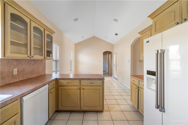 kitchen featuring lofted ceiling, light tile patterned floors, white appliances, backsplash, and kitchen peninsula