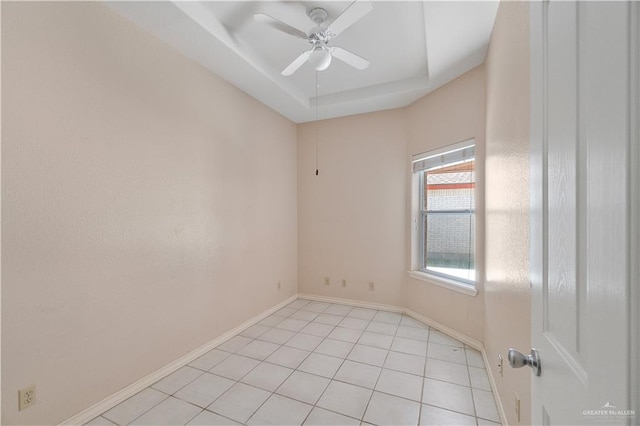 tiled spare room with a raised ceiling and ceiling fan