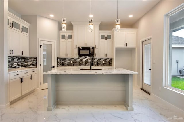 2605 Linva Ave, Edinburg, TX 78542 - kitchen with black microwave, light marble finish floors, recessed lighting, decorative backsplash, and a kitchen island with sink