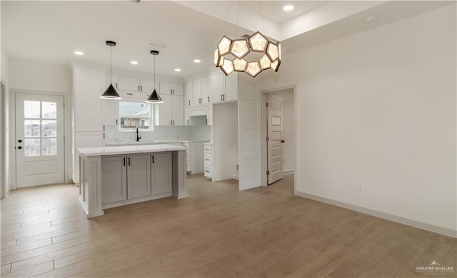 405 S 23rd St, Hidalgo, TX 78537 - kitchen with white cabinets, a kitchen island, light wood finished floors, light countertops, and recessed lighting