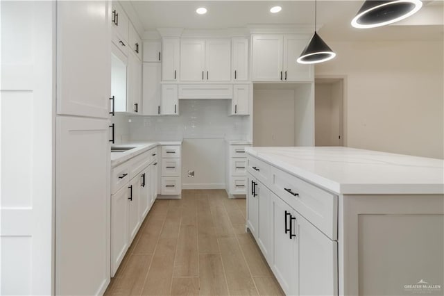 405 S 23rd St, Hidalgo, TX 78537 - kitchen featuring recessed lighting, decorative backsplash, white cabinetry, light wood-style floors, and a kitchen island