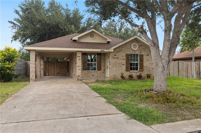 1815 W Adelita St, Weslaco, TX 78599 - view of front of property featuring brick siding, driveway, a shingled roof, and an attached carport