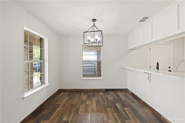 1815 W Adelita St, Weslaco, TX 78599 - unfurnished dining area featuring a chandelier and dark wood-style flooring