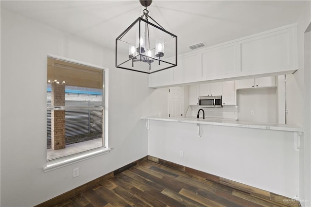 1815 W Adelita St, Weslaco, TX 78599 - unfurnished dining area featuring dark wood-type flooring and a chandelier