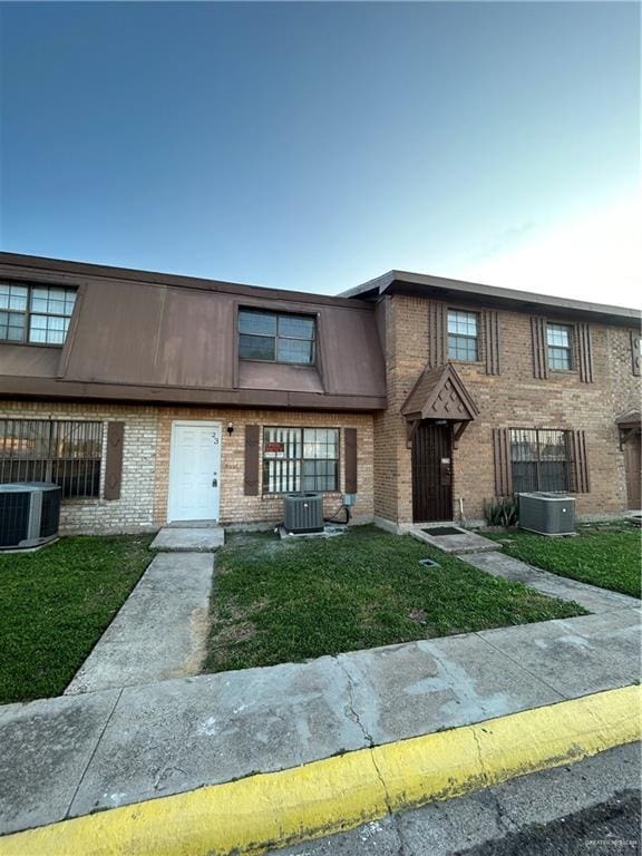 view of front facade featuring central AC and a front lawn