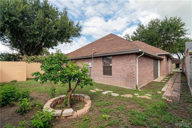 view of property exterior with fence and brick siding