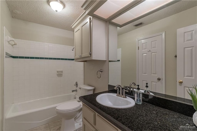 bathroom featuring toilet, a textured ceiling, shower / tub combination, vanity, and tile patterned floors