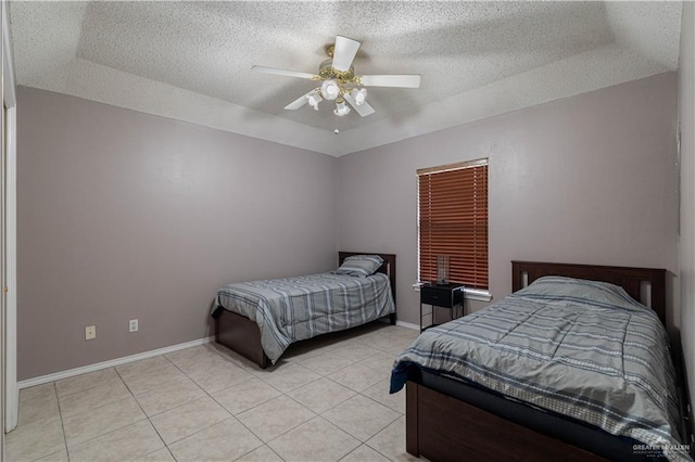 bedroom featuring light tile patterned floors, a textured ceiling, a ceiling fan, and baseboards