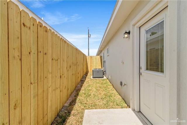 view of yard with central AC unit and fence