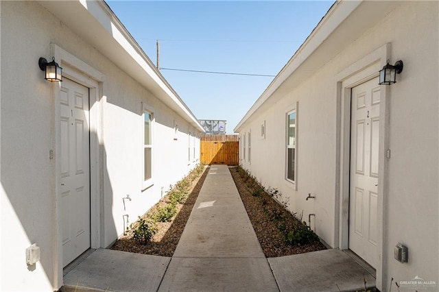 view of side of property featuring fence and stucco siding