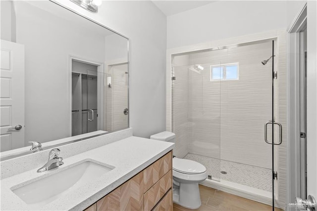 full bath with toilet, a stall shower, and vanity