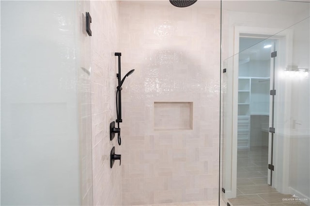 bathroom with a shower with door and tile patterned flooring