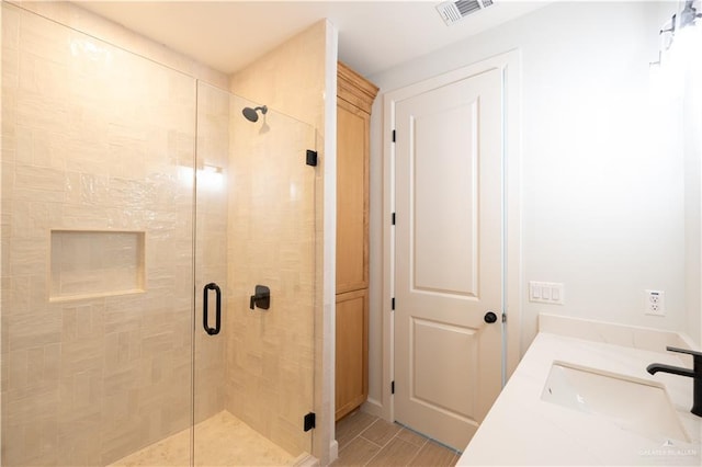 bathroom with hardwood / wood-style floors, vanity, and a shower with door