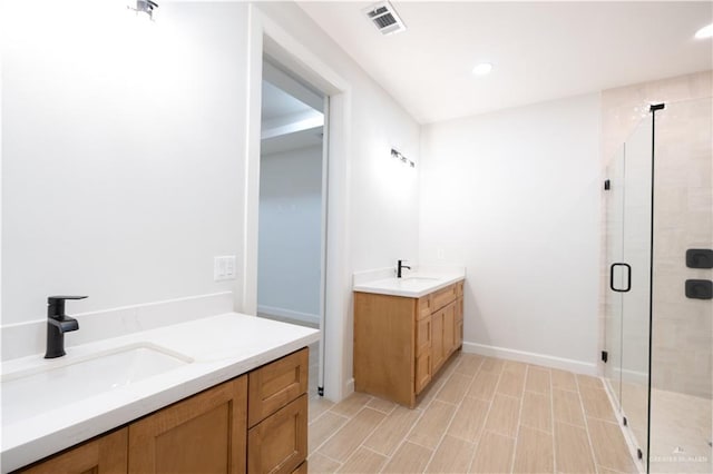 bathroom featuring vanity and a shower with door