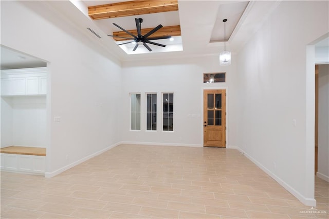 unfurnished room featuring beamed ceiling, a high ceiling, light wood-type flooring, and ceiling fan