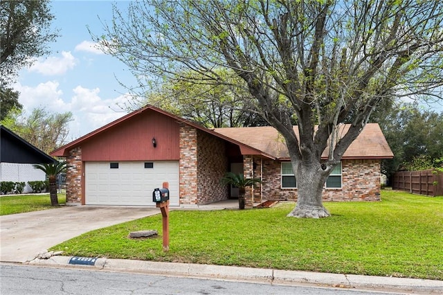 view of front facade with driveway, brick siding, a front yard, and fence